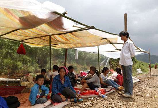 暴雨馬上來(lái)臨，村民們?cè)诤?jiǎn)易帳篷下躲雨。澎湃新聞 程藝輝 圖