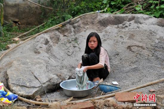 8月9日，云南巧家紅石巖村，10歲的劉鑫蕊在洗自己的衣服
