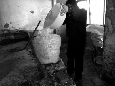 作坊內(nèi)工人用攪拌有漂白粉的藥水給豆芽增白。