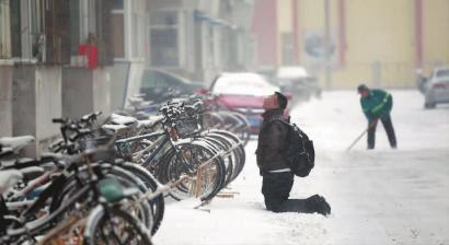 小伙子跪在樓前，一直抬頭看著樓上。 孫立國(guó)/攝