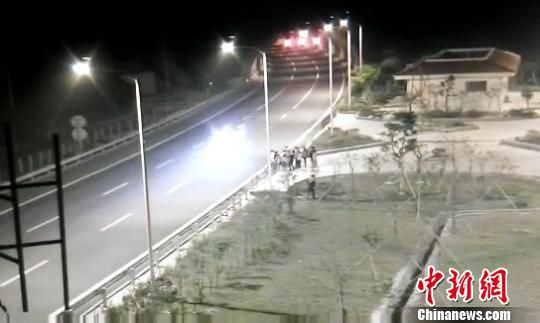 看到車輛經(jīng)過，孩子們便急忙跑到一旁的花圃上?！【焦﹫D　攝