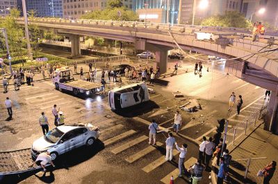 路虎沖下國貿(mào)橋砸中一輛起亞轎車，橋上厚達(dá)幾十厘米的水泥護(hù)欄被撞斷，碎石四處散落，數(shù)十群眾在現(xiàn)場圍觀。