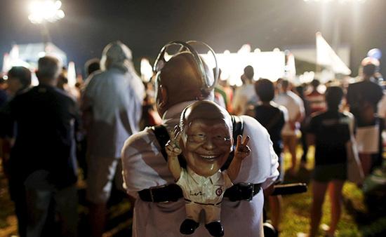 9月4日，新加坡，執(zhí)政黨的一場(chǎng)集會(huì)上，一名支持者背著一個(gè)李光耀的人偶。