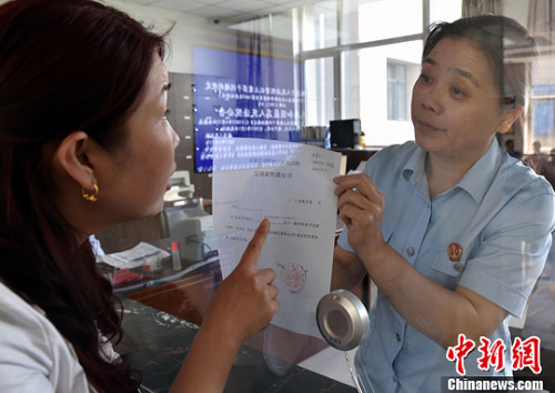 資料圖：2015年5月4日，河北石家莊市橋西區(qū)人民法院立案庭庭長(zhǎng)齊燕正在為立案人辦理相關(guān)手續(xù)，完成整個(gè)過(guò)程只用了5分鐘。當(dāng)日是立案登記制改革首個(gè)工作日，該院共立案36件，立案率達(dá)到90%。中新社發(fā) 翟羽佳 攝