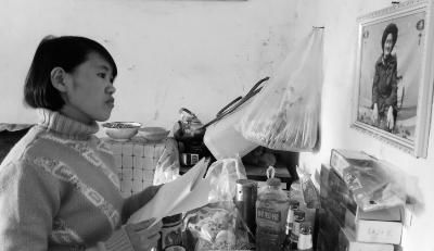 錢仁鳳站在母親遺像前。未能見母親最后一面是她的一大遺憾。