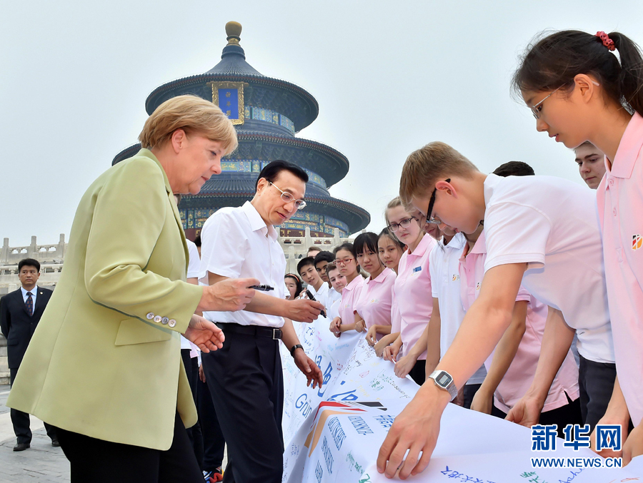 李克強同默克爾在紀念橫幅上簽名。