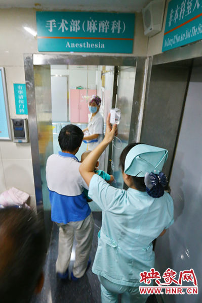 大龍被爺爺抱著進入麻醉室