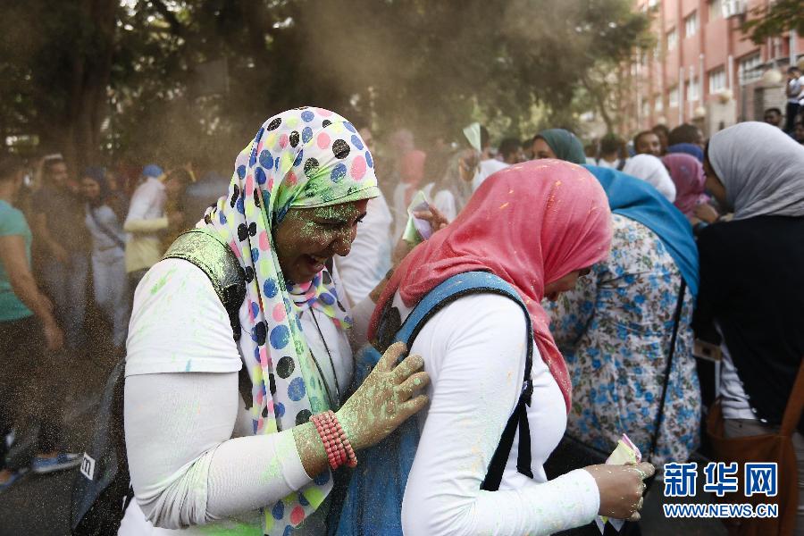 10月16日，在埃及首都開羅，兩名女青年在“彩色跑”活動中躲避人們拋撒的彩色粉末。