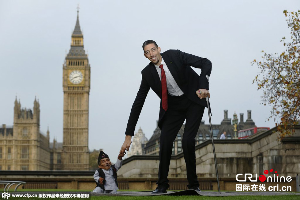 當地時間2014年11月13日，英國倫敦，世界上最矮的男子錢德拉·巴哈杜爾·唐吉與世界上最高的男子蘇