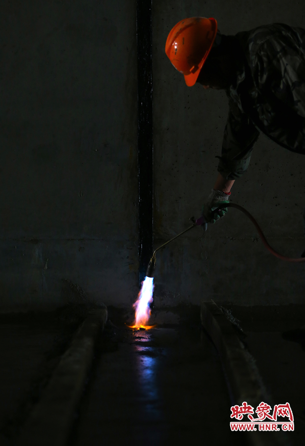 工人師傅用噴槍烘干地面，便于做防水處理