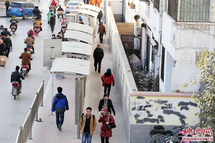 墻內(nèi)扔著垃圾，墻面上涂滿了牛皮癬小廣告，異常顯眼。