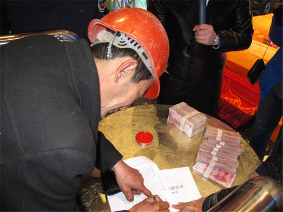 農(nóng)民工在現(xiàn)場領(lǐng)取工資。
