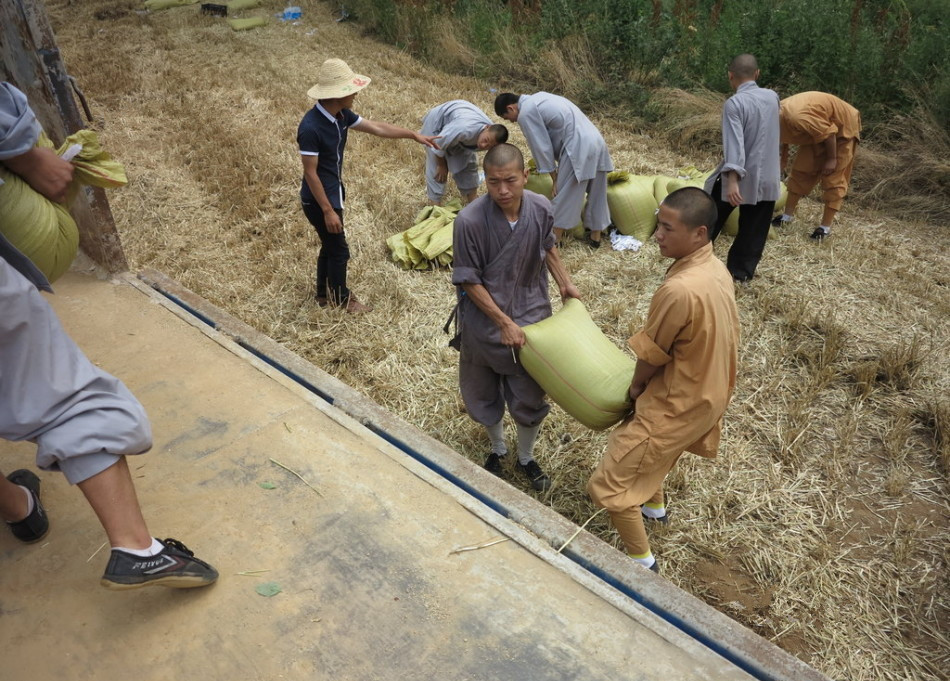 武僧將打包后的糧食集中至運(yùn)輸車輛上。