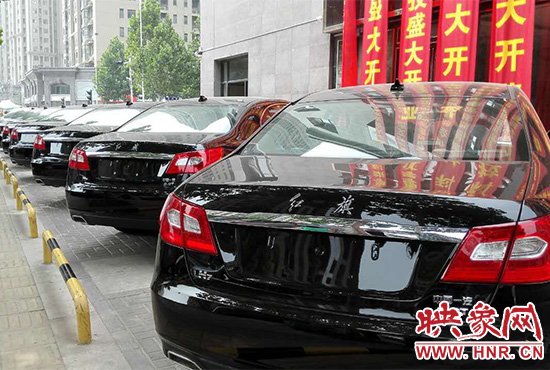 路邊一棟樓上懸掛著二三十條紅色條幅，全部是祝賀一家公司開(kāi)業(yè)的。