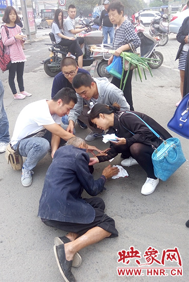 一些愛(ài)心市民在撥打了110和120后，上前給老人擦臉上的血跡。