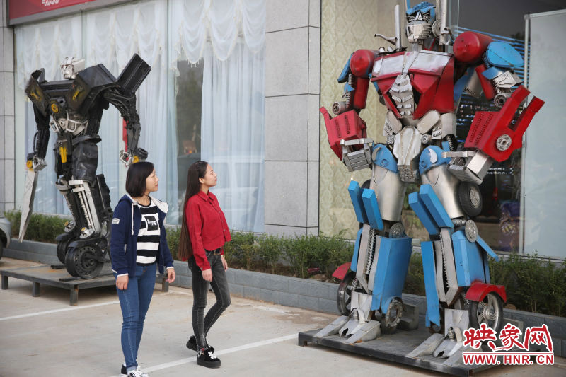 10月14日，市民在參觀(guān)河南省平頂山市寶豐縣一家企業(yè)門(mén)前的“變形金剛”。