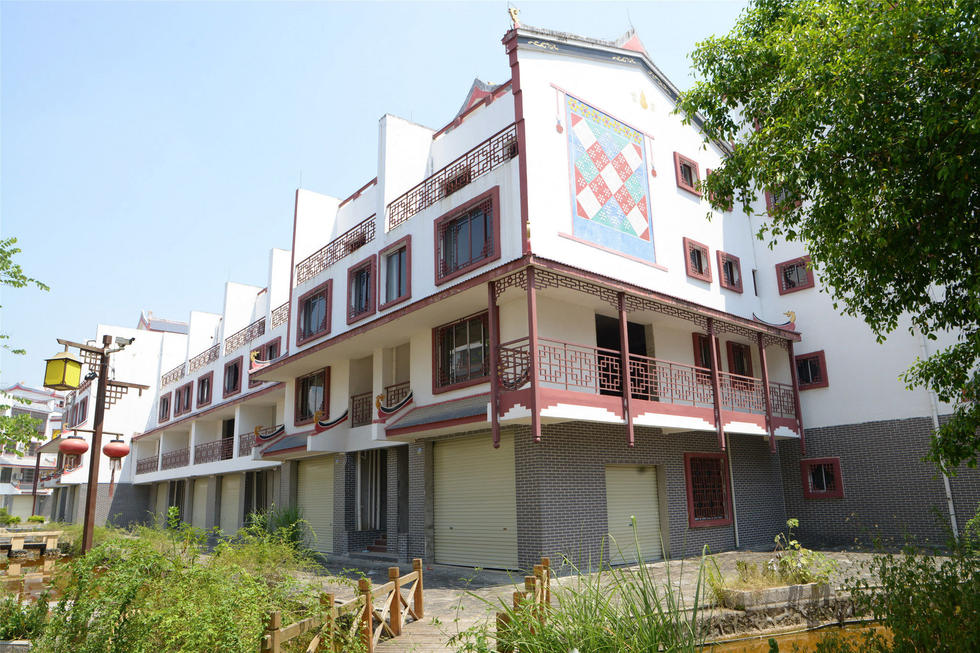 2016年7月26日，村民在廣西來賓市忻城縣隆達山水福城荒廢別墅間放牛。