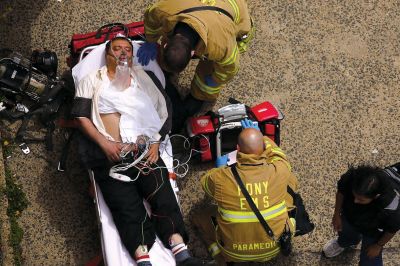 2日，救援人員在美國紐約地鐵事故車輛內(nèi)緊急疏散一名受傷乘客。圖/CFP