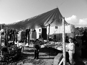 黎巴嫩一敘利亞難民營，難民支起攤鋪賣衣服掙錢。