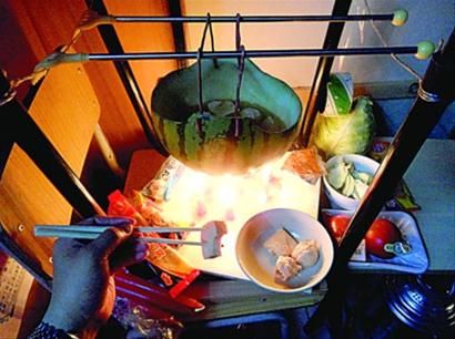 兩張椅子被面對面疊在一起，穿了兩根線的西瓜皮就懸空在椅腳中間，下面有蠟燭加熱，這就是西瓜火鍋。