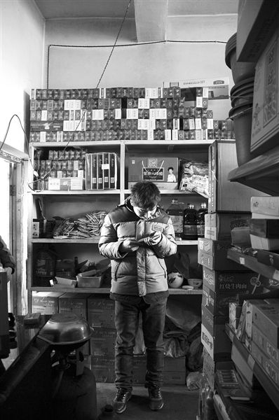 1月21日，周瑋在自家的超市里玩計算器。