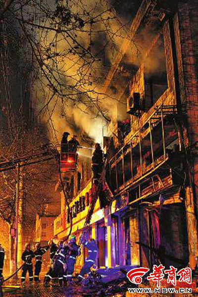 昨日22時(shí)10分，西安市豐慶路南小巷南口，消防官兵架梯子登上二樓施救 本組圖片由本報(bào)記者 閆文青 攝