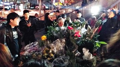 昨晚7時(shí)許，三里屯太古里西邊附近一過街天橋旁邊，聞?dòng)嵍恋木W(wǎng)友圍住了賣花老人，爭(zhēng)相買花。 網(wǎng)友“行者橙子”供圖