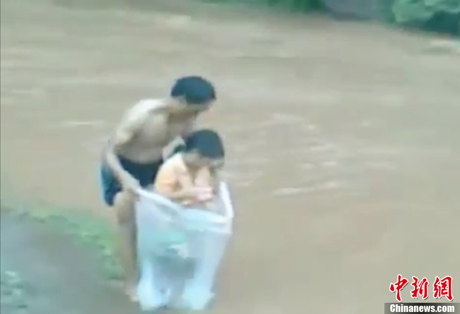 越南一村莊家長用塑料袋運孩子過河上學(xué) 越南一村莊家長用塑料袋運孩子過河上學(xué)