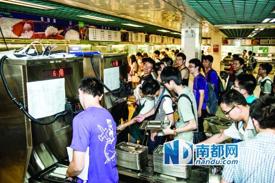 昨日，華南理工大學(xué)一食堂內(nèi)，學(xué)生們正在使用新安裝的自動(dòng)打飯機(jī)打飯。中新社發(fā)
