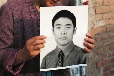 5月19日，朝陽北路，母親捧著張東文的遺像。新京報記者 侯少卿 攝