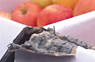 8月29日，新發(fā)地市場(chǎng)，一箱用“加重紙箱”包裝的蘋果正待售，紙箱夾層內(nèi)灰黑色的增重填充物清晰可見