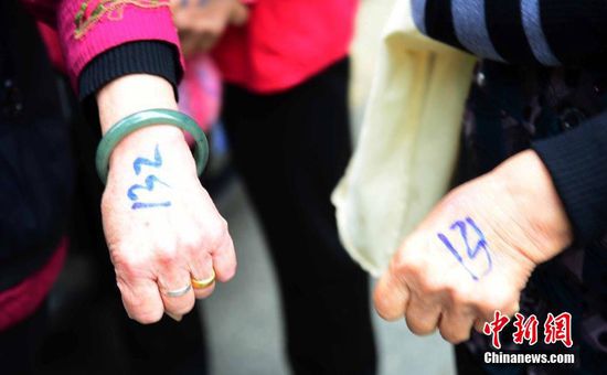 圖為10月28日，在江西九江市一家羊絨皮草服裝服飾博覽會(huì)現(xiàn)場(chǎng)，老人們正在頂著寒風(fēng)排隊(duì)等待領(lǐng)取10元代金劵。