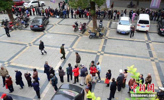 圖為10月28日，在江西九江市一家羊絨皮草服裝服飾博覽會(huì)現(xiàn)場(chǎng)，老人們正在頂著寒風(fēng)排隊(duì)等待領(lǐng)取10元代金劵。