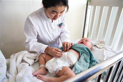 昨日，北京兒童醫(yī)院，護(hù)士為即將出院的被扎鋼針女?huà)霗z查傷口恢復(fù)情況。記者 高瑋 攝