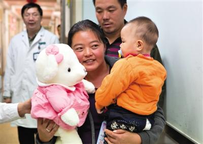 昨日上午，被扎針女?huà)氲哪赣H抱著孩子和醫(yī)護(hù)人員送的玩偶準(zhǔn)備出院，院方稱(chēng)孩子術(shù)后恢復(fù)良好。記者 高瑋 攝