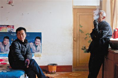 父親抽煙，兒子不語。逃跑的越南新娘，給袁迎賓父子帶來的是失落。新京報記者 周崗峰 攝