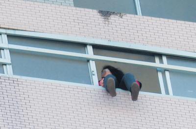 28樓的窗臺(tái)上坐著一名女子，其兩條腿耷拉在室外，不停地?cái)[動(dòng)。