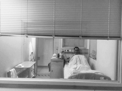 楊杰在醫(yī)院隔離病房中，沖記者揮了揮手。