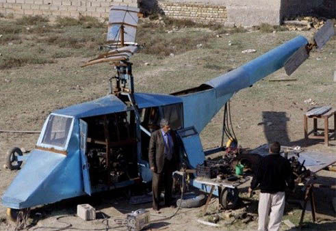 哈蒂姆·卡迪姆·薩爾曼正與工人交談，背后就是他正在制造的直升機(jī)