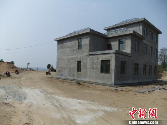 鴨河水庫庫區(qū)邊的新建別墅，一面墻上寫著“拆”，另一邊在加緊施工。吳揚　攝